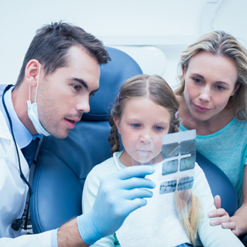 Dentist showing little girl her X-rays