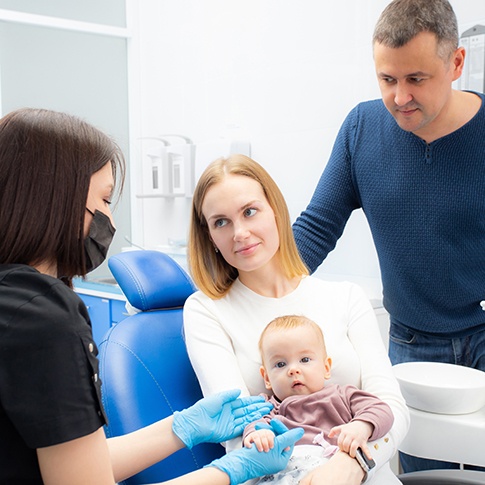 Mother and father holding baby at the dentist’s office