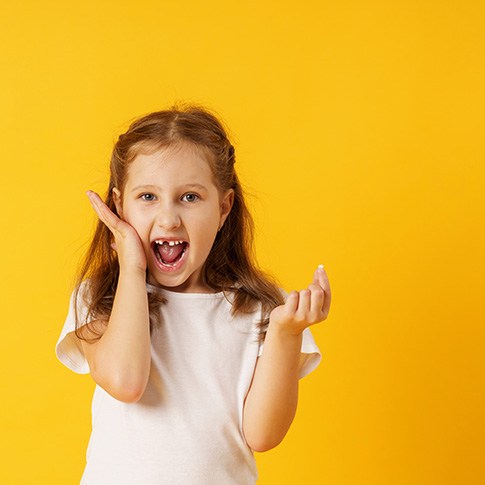 Little girl holding extracted tooth