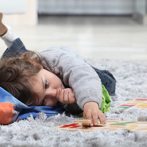 Child sucking thumb while on the floor