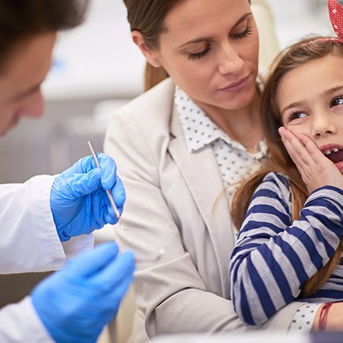 Young girl and mother at dentist for emergency