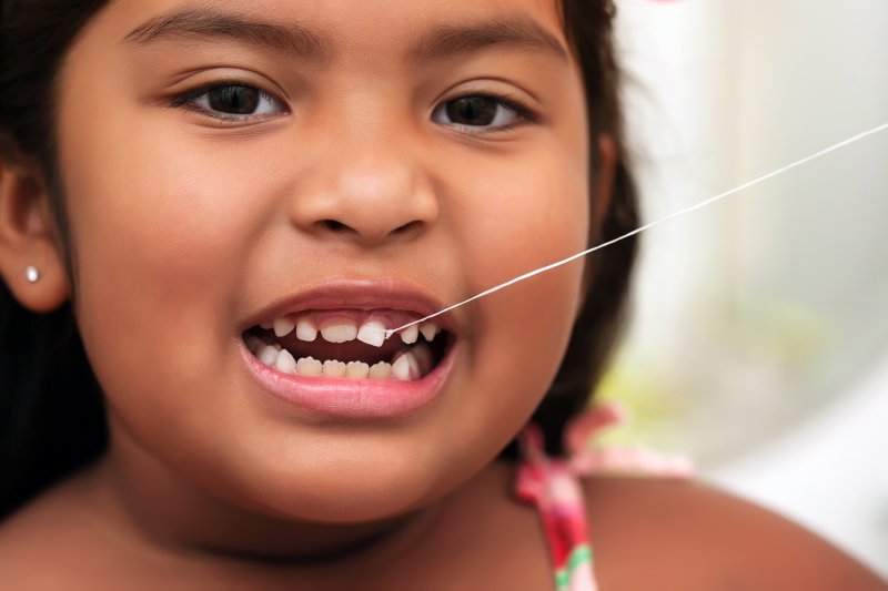 a young child with a loose tooth and string attached