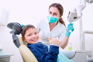 a child smiling while receiving dental care