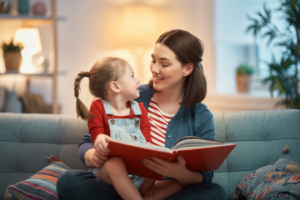 a mother reading a book to her young child